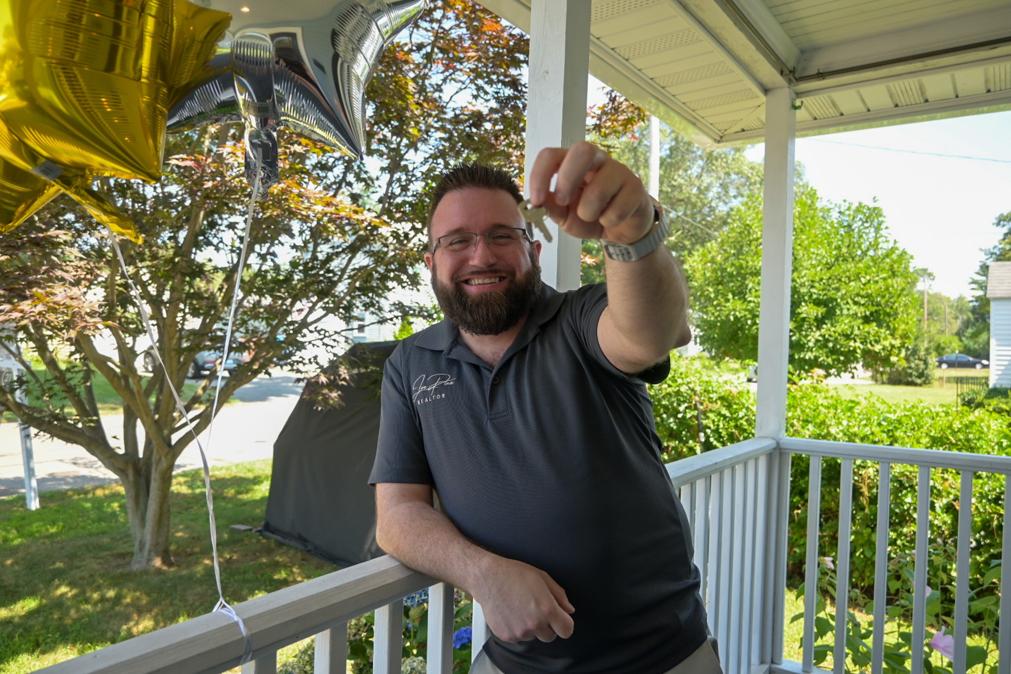 Joe Pine holding a key on a front porch